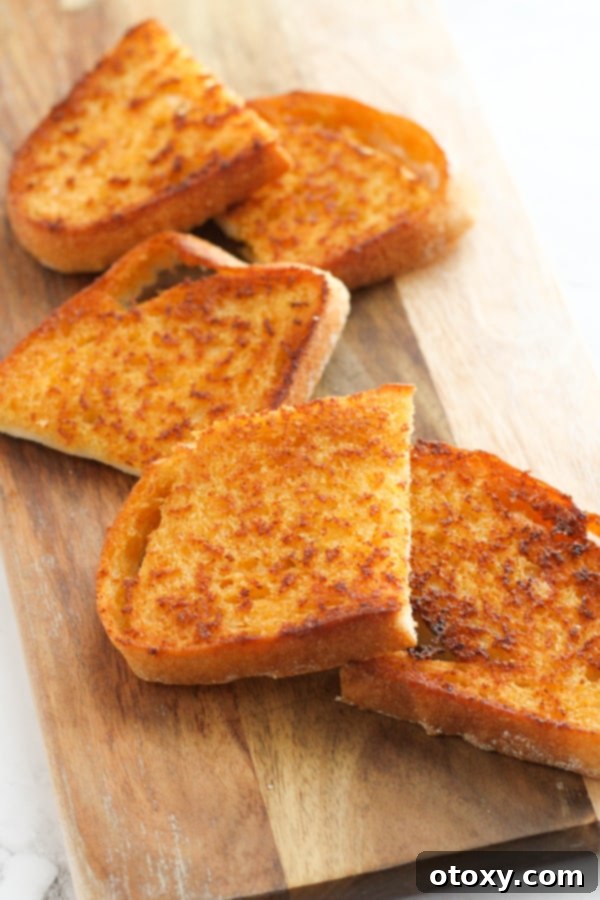 slices of cheese toast on a wooden serving board.