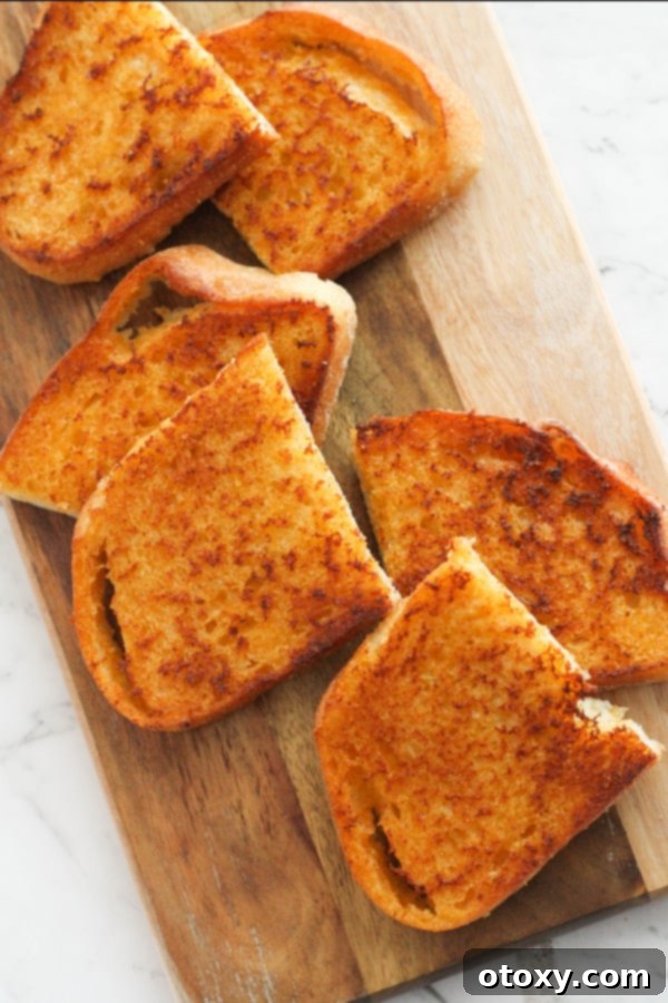 slices of cheese toast on a wooden serving board.