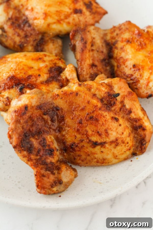 Ultimate Air Fryer Chicken Thighs 8 chicken thighs on a plate with parsley.