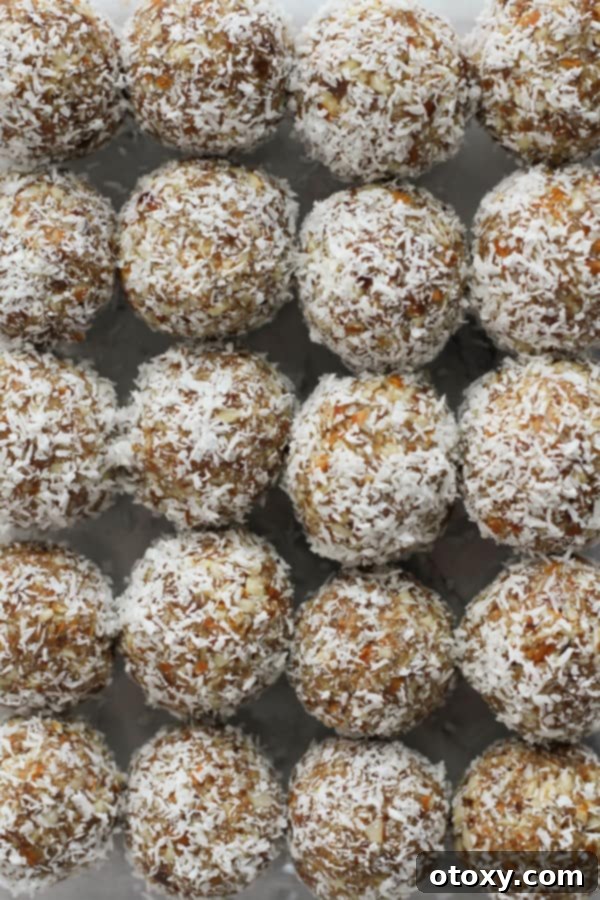 Tropical Date Energy Bites 3 Neatly arranged coconut date balls in a clear glass container, showcasing their perfect snack size.