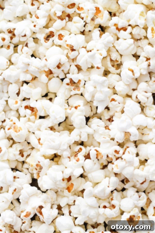Freshly popped popcorn spread out on a baking tray.