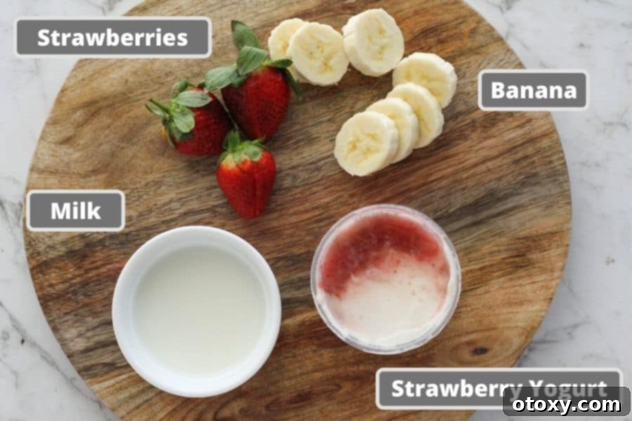 Ingredients for strawberry smoothie laid out: milk, strawberry yogurt, banana slices, and whole strawberries.