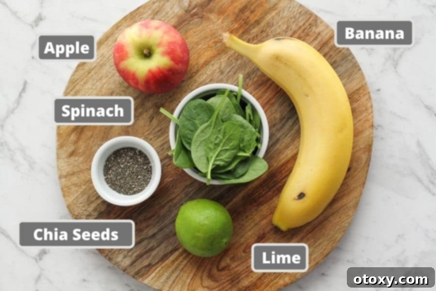 Vibrant Green Apple Smoothie 4 Fresh ingredients for a spinach apple smoothie laid out on a rustic wooden board, including baby spinach, an apple, a banana, lime, and chia seeds.