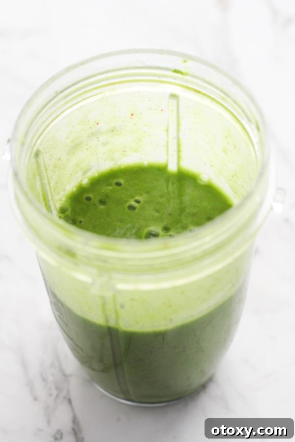Vibrant Green Apple Smoothie 7 A high-speed blender actively mixing a vibrant green spinach apple smoothie, creating a smooth, creamy texture.