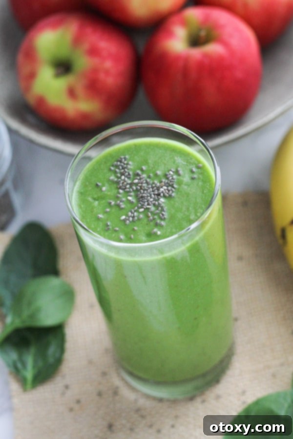 Vibrant Green Apple Smoothie 8 A close-up of an apple spinach smoothie in a tall glass, beautifully topped with a sprinkle of chia seeds.