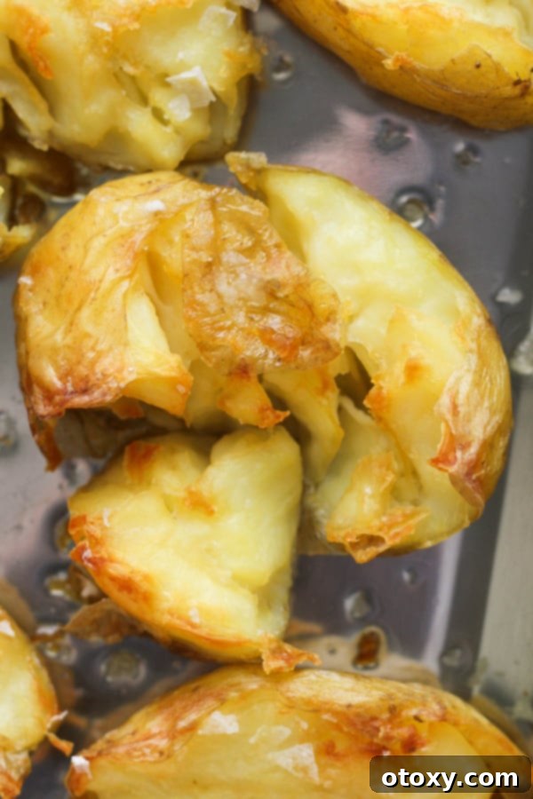 Close-up of a single glass potato, revealing its crispy, golden exterior and a scattering of delicate salt flakes.