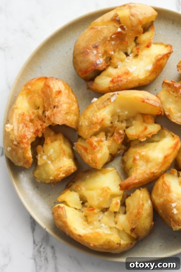 A perfectly cooked plate of Annabel Crabb's Glass Potatoes, sprinkled with salt flakes, invitingly ready to be enjoyed.