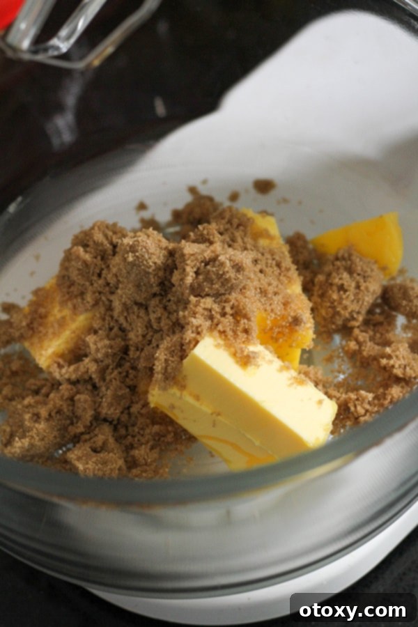 Creamed butter and brown sugar in a mixing bowl, ready for the next ingredient.