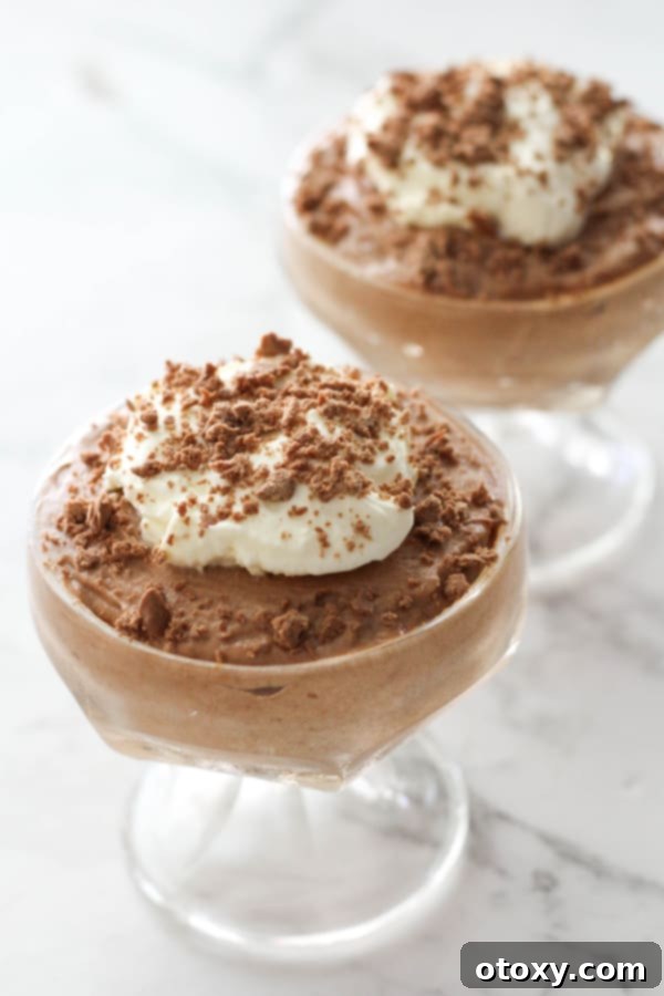 Two ingredient chocolate mousse served in elegant dessert cups, garnished with fresh berries and chocolate shavings, ready to be enjoyed.