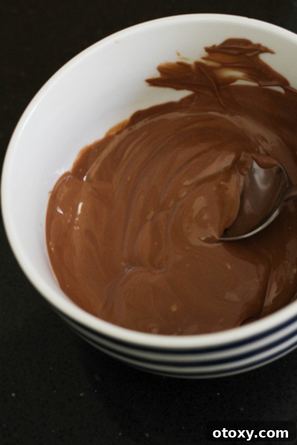 A bowl of perfectly melted chocolate, smooth and glossy, ready for the next step in making a quick chocolate mousse.