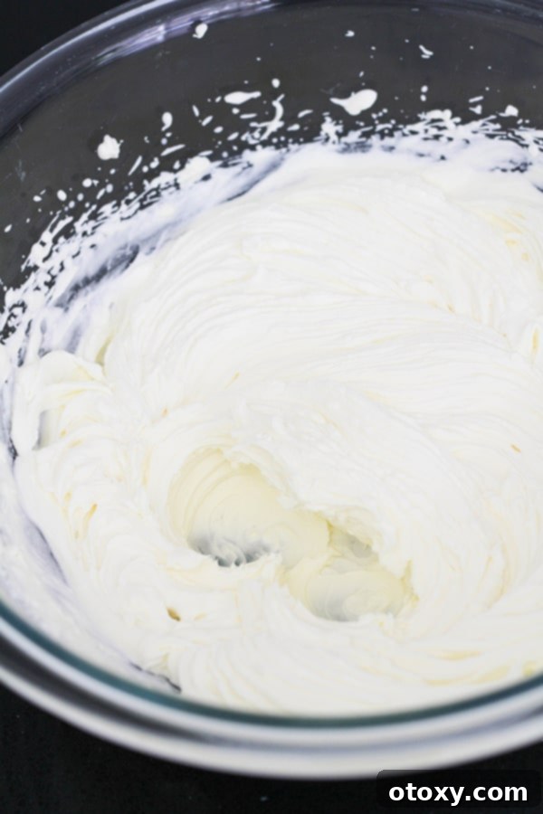 Fluffy, perfectly whipped cream in a clear glass bowl, showcasing its stiff peaks, essential for a light mousse.