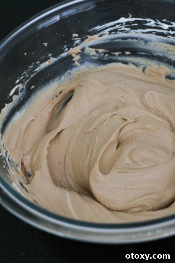 A beautifully combined chocolate mousse mixture in a glass bowl, showcasing its rich brown color and light texture before chilling.