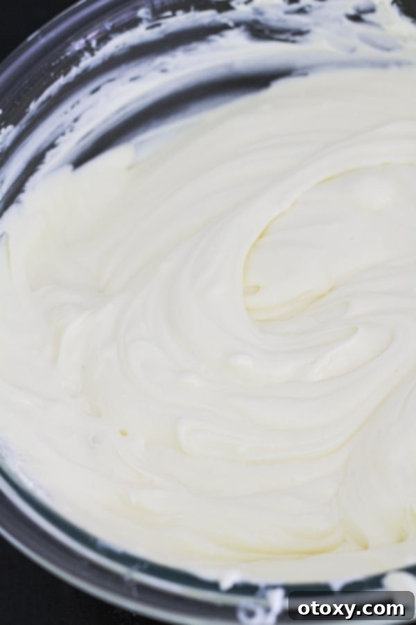 Light and fluffy cheesecake mixture, prepared in a glass bowl, ready to be poured onto the crust.
