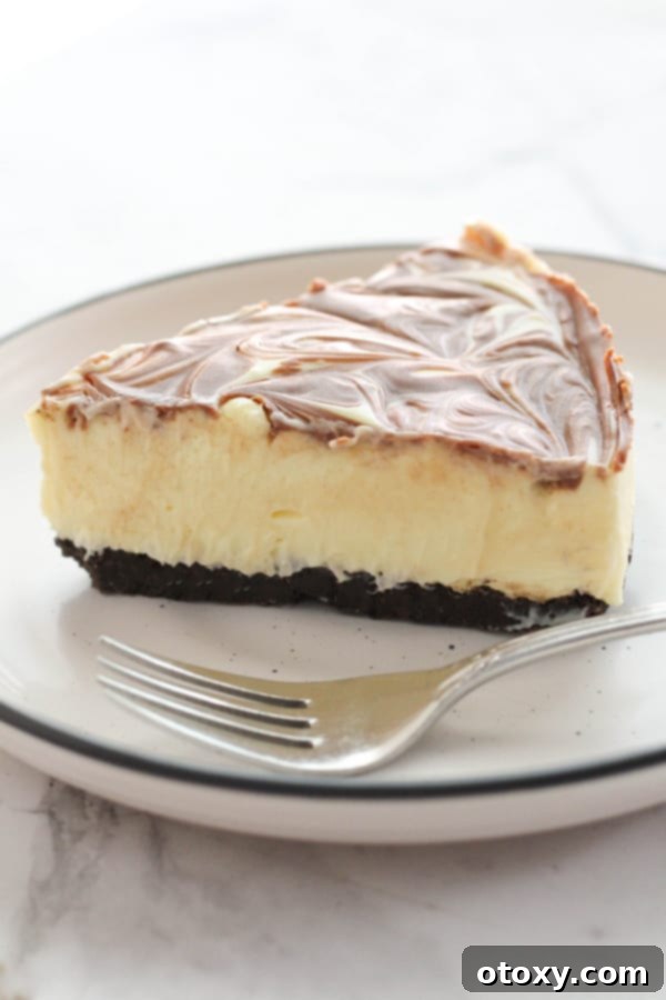 A freshly cut slice of marble cheesecake, showing its smooth texture and elegant swirl, served on a plate with a fork.