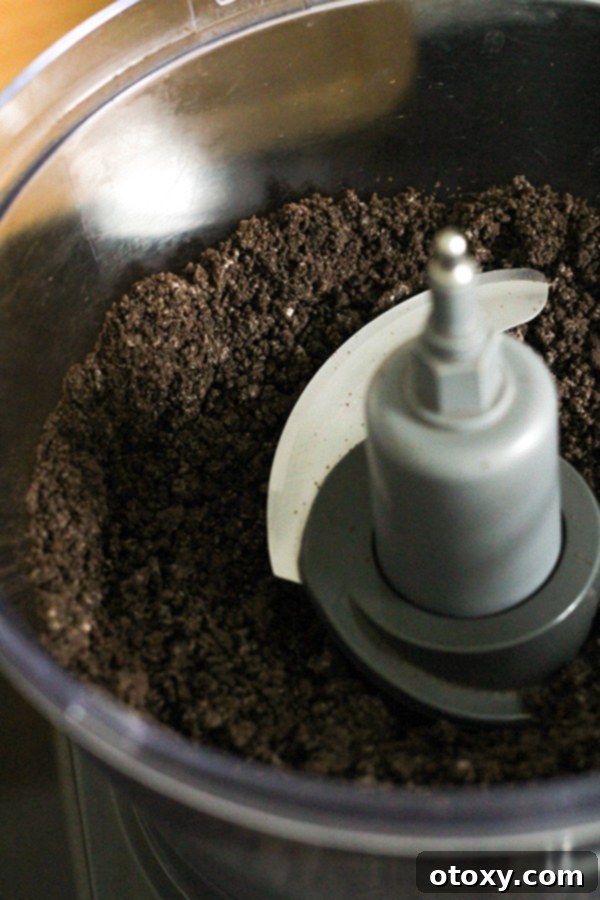 Oreo cookies being processed into fine crumbs in a food processor.
