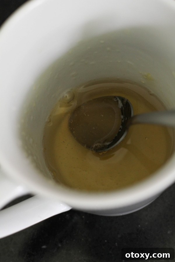 Gelatine powder mixed with water in a small cup, blooming and ready for use.