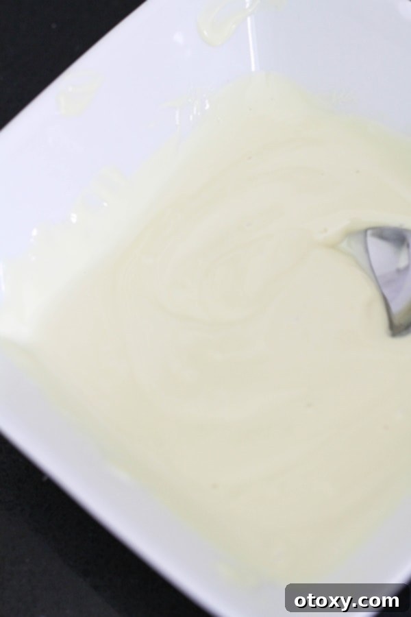 Smooth, melted white chocolate in a microwave-safe bowl.