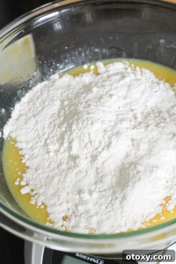 flour on top of cupcake mixture in a glass bowl.