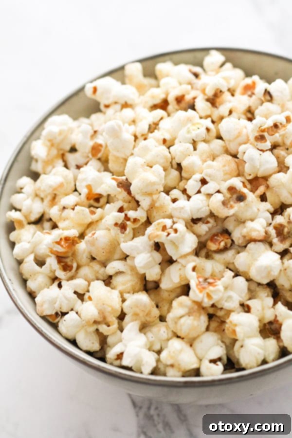 A grey bowl brimming with golden cinnamon sugar popcorn, ready to be enjoyed.