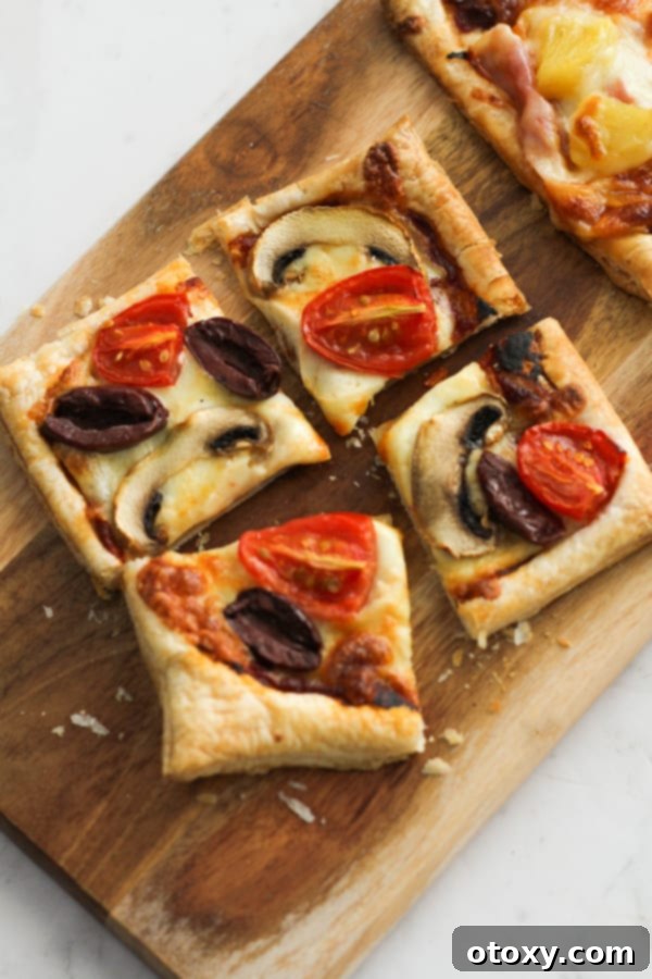 A close-up of sliced puff pastry pizzas on a wooden serving board, ready to be enjoyed.