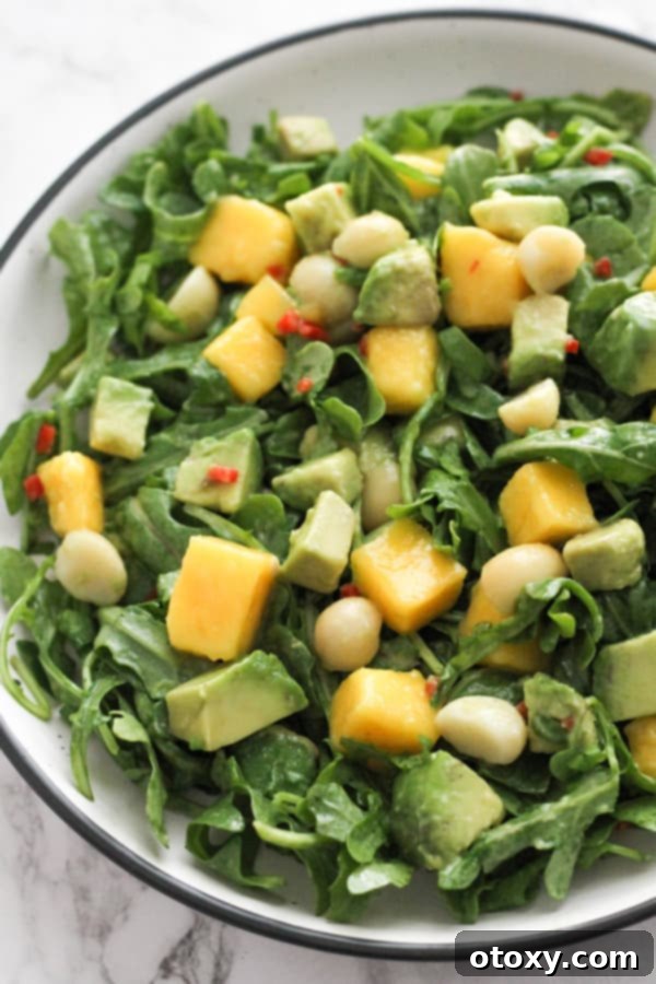 Close-up of a beautifully plated Mango Avocado Salad in a white bowl, showcasing the vibrant colors and fresh ingredients.