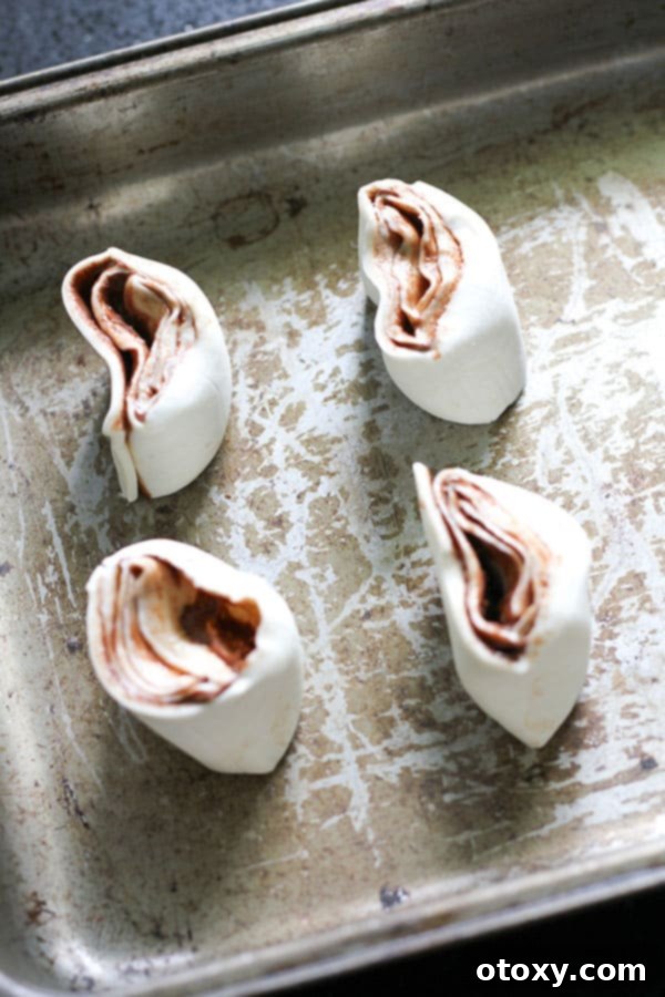 Chocolate Nutella Swirl Pastries Baked or Air Fried 7 several uncooked pinwheels arranged on a baking tray, ready for the oven.