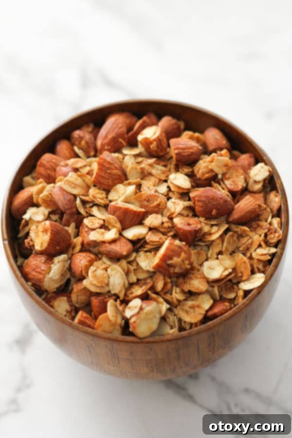 Cooled Air Fryer Granola in a rustic wooden bowl, showcasing its crunchy texture and readiness for serving or storage.