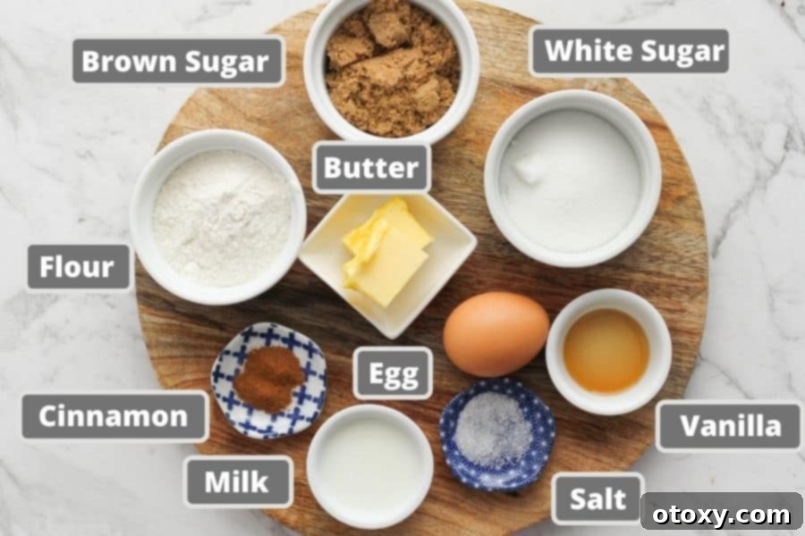 A selection of muffin ingredients neatly displayed on a rustic wooden board, including butter, sugar, flour, and cinnamon.
