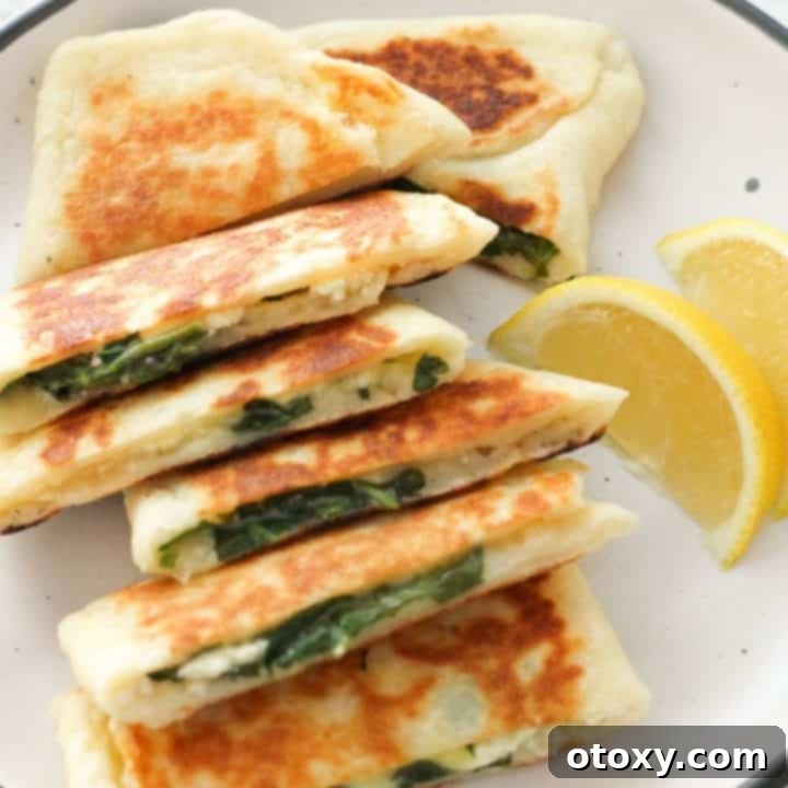 Crispy golden Spinach and Feta Gozleme stacked on a white plate, ready to be served.