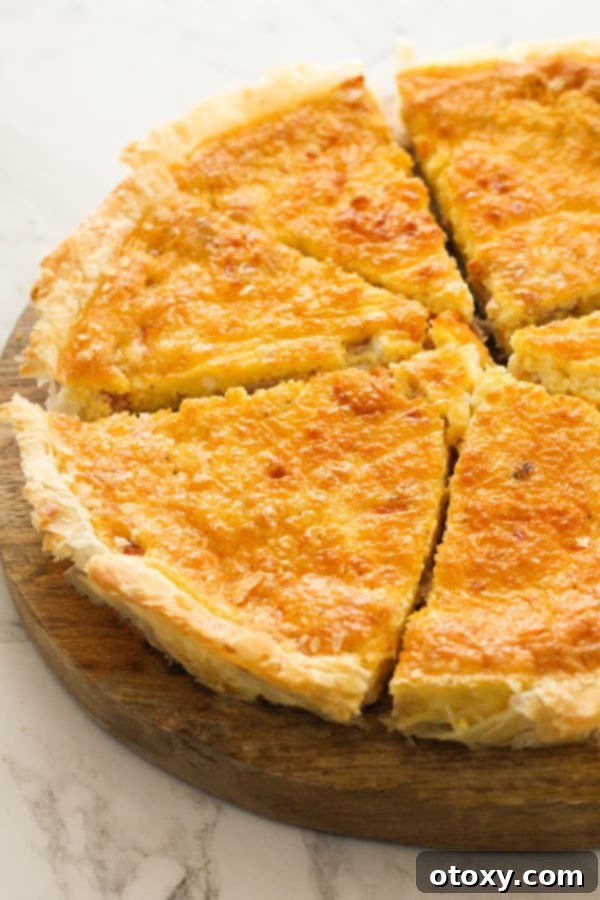 A perfectly sliced bacon and egg pie resting on a rustic wooden board, showcasing its golden crust and rich, savory filling.