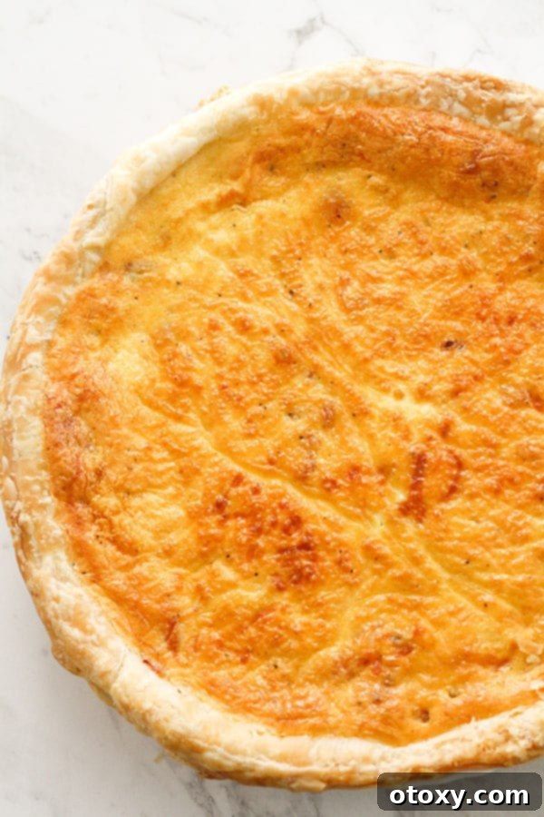 A freshly baked, golden-brown bacon and egg pie, hot out of the oven and perfectly set.