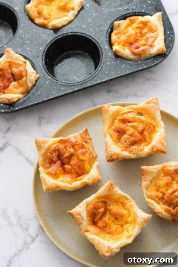 A plate of golden brown mini bacon and egg pies, perfect for breakfast or an appetizer.