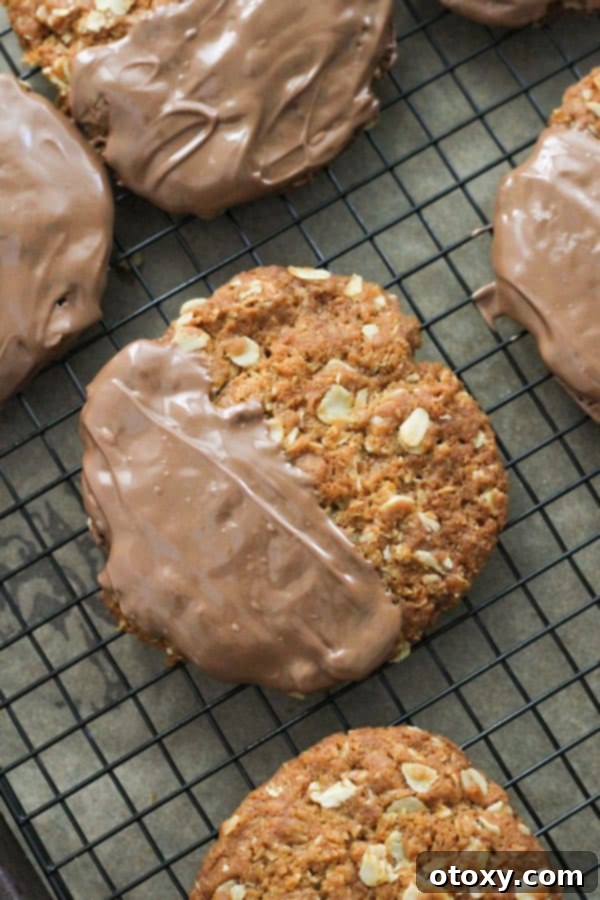 Irresistible Chocolate Anzac Biscuits on a cooling rack, freshly dipped in chocolate.