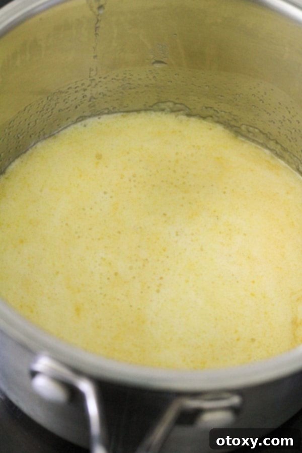 Melted butter and golden syrup creating a frothy mixture in a saucepan.