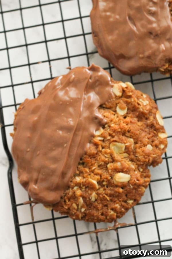 Delicious Chocolate Anzac Biscuits with perfectly set chocolate, arranged on a wire rack.