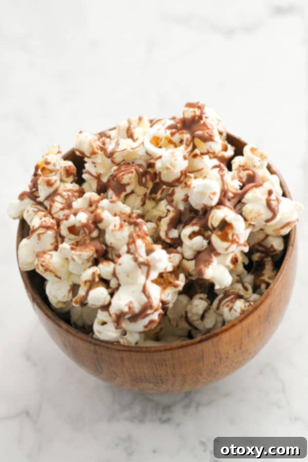 Decadent Chocolate Popcorn 3 chocolate drizzled popcorn in a bowl.