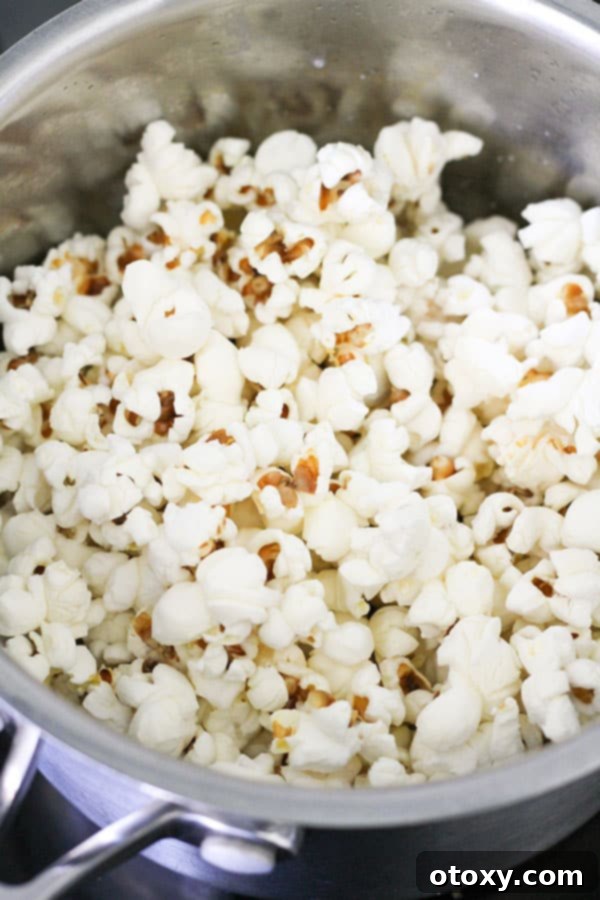 Decadent Chocolate Popcorn 6 freshly popped popcorn in a saucepan.