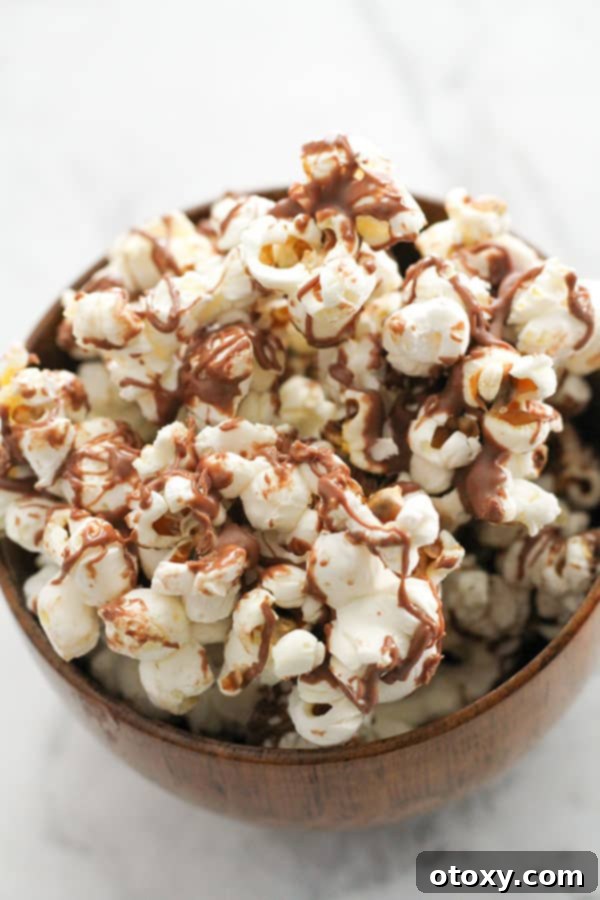 Decadent Chocolate Popcorn 10 chocolate drizzled popcorn in a bowl.