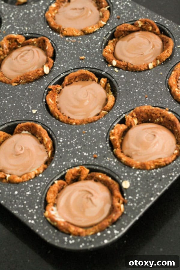 Luscious Caramel Tartlets 8 caramel tarts topped with chocolate in a muffin tray.