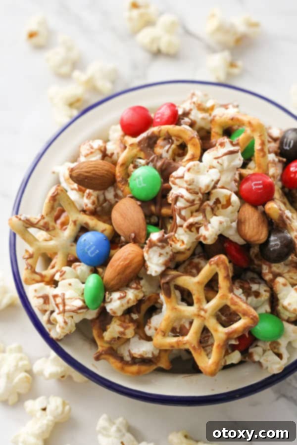 A generous serving of Popcorn Trail Mix in a crisp white bowl, ready for snacking.