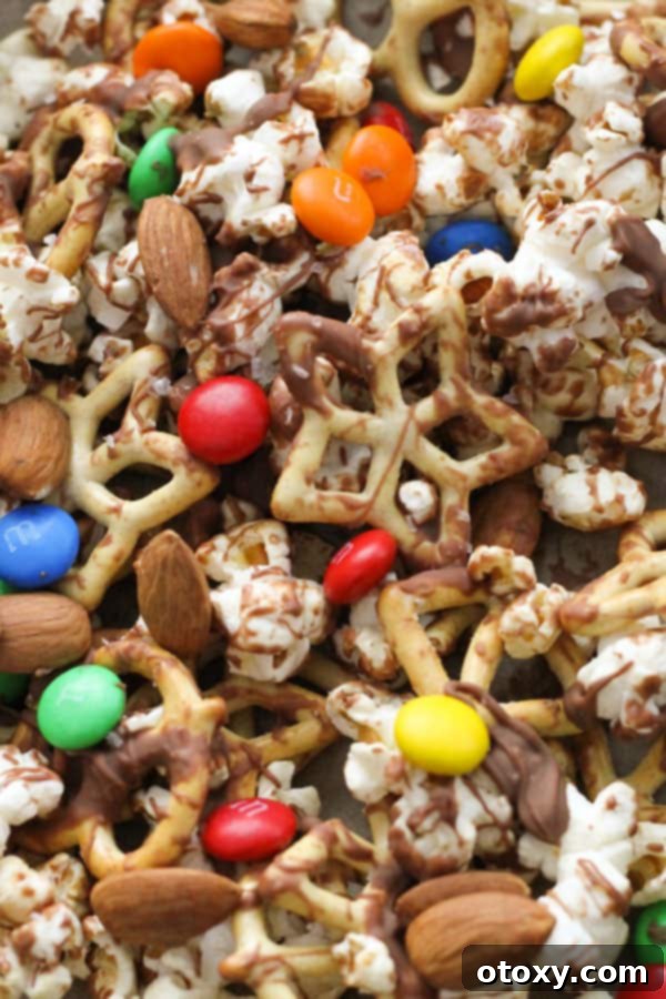 A freshly prepared Popcorn Trail Mix spread evenly on a baking tray, showcasing its colorful ingredients.