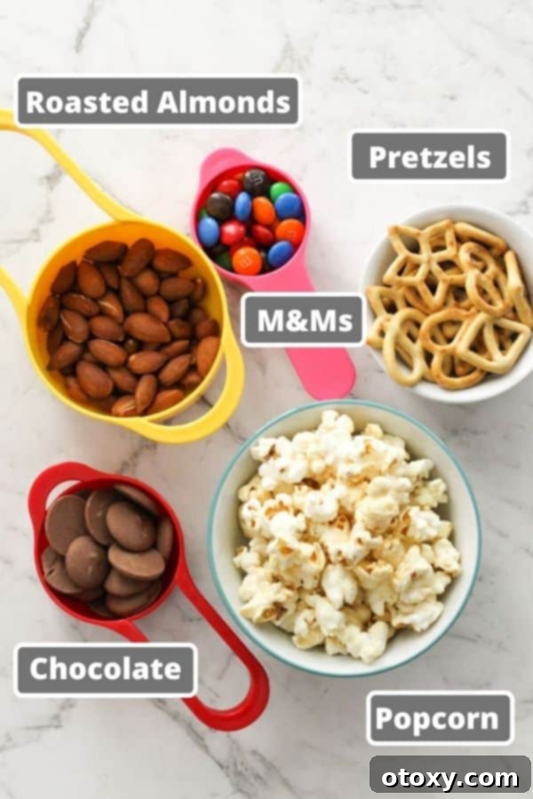 A vibrant selection of Popcorn Trail Mix ingredients laid out on a white marble background.