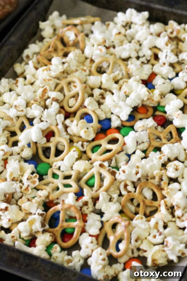 Various dry ingredients for Popcorn Trail Mix are laid out on a baking tray before chocolate is added.