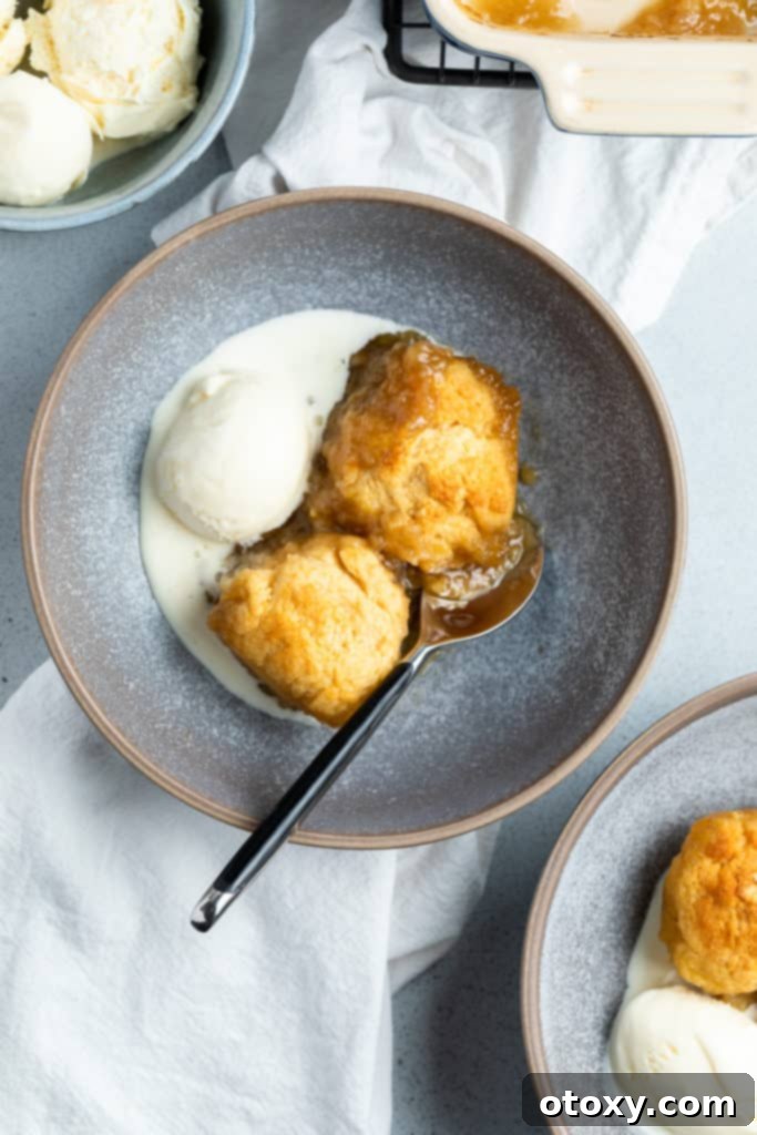 golden syrup dumplings in a bowl with ice cream.