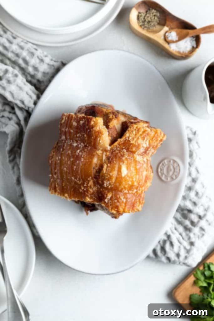 Perfectly cooked air fryer roast pork resting on a white platter, ready to be served.