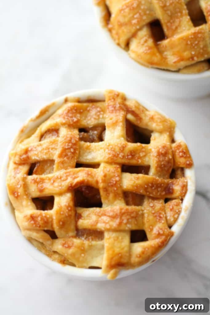 two mini apple pies in white ramekins.
