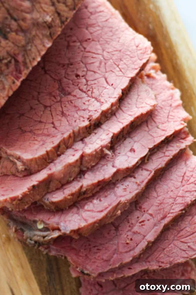 slices of corned beef on a wooden serving board.