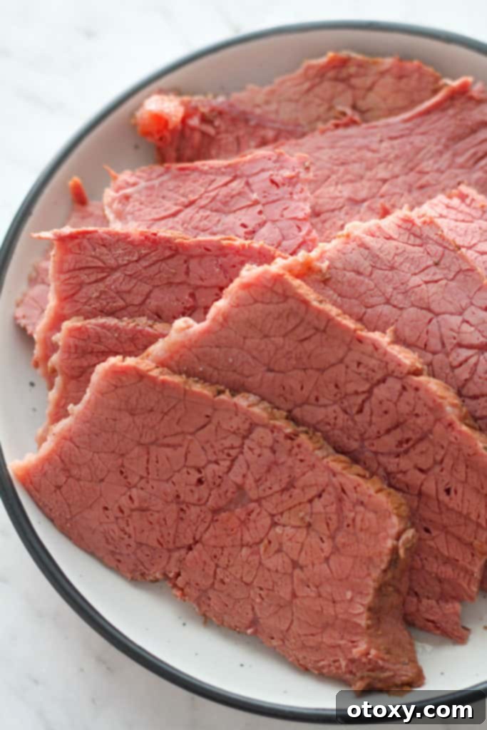 slices of corned beef on a white plate.