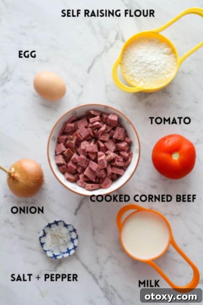 A flat lay of corned beef fritter ingredients on a white marble background, including milk, egg, tomato, onion, and cooked corned beef cubes.