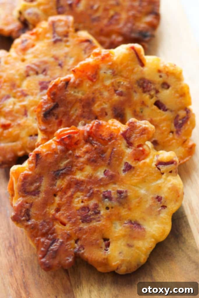 An appetizing display of golden-brown corned beef fritters resting on a rustic wooden serving board.